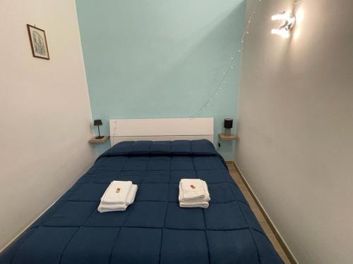 un letto in una stanza con due asciugamani bianchi di Appartamento Cosy Centro Storico a Barletta