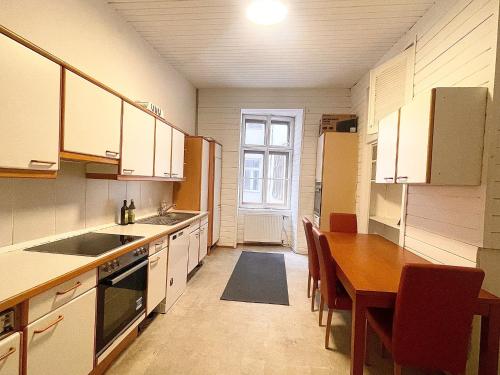 a kitchen with a wooden table and a dining room at Prater City Hostel in Vienna