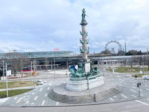 eine Statue in der Mitte eines Platzes mit Achterbahn in der Unterkunft Prater City Hostel in Wien