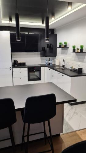 a kitchen with white cabinets and a table and chairs at Apartament Sofia Kowary in Kowary