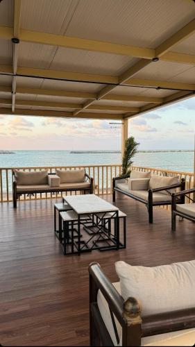 a deck with couches and a table and the ocean at sea breeze RAK in Ras al Khaimah