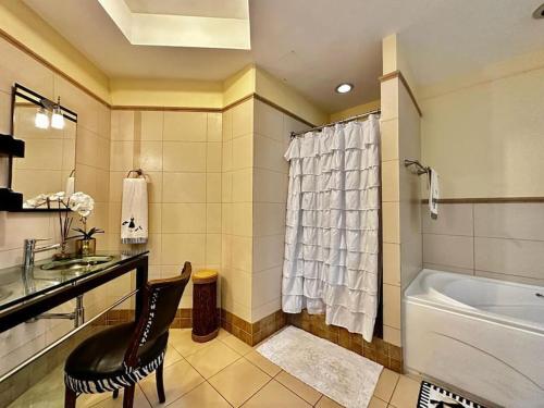 a bathroom with a tub and a sink and a toilet at Luxurious Retreat in Port-of-Spain