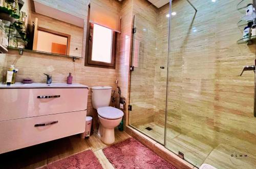 a bathroom with a toilet and a glass shower at Luxurious Stay at Prestigia Golf Marrakech with Golf Course, Pool, and Breathtaking Atlas Mountains View in Marrakech