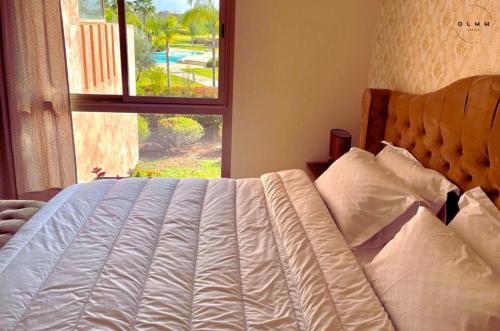 1 cama en un dormitorio con ventana en Luxurious Stay at Prestigia Golf Marrakech with Golf Course, Pool, and Breathtaking Atlas Mountains View en Marrakech