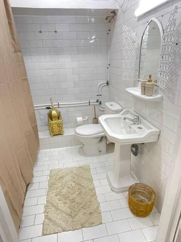 a white bathroom with a sink and a toilet at Dar Yasmina in Sidi Ifni