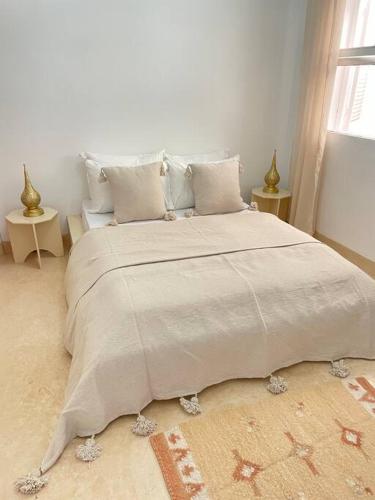 a white bedroom with a large bed with pillows at Dar Yasmina in Sidi Ifni