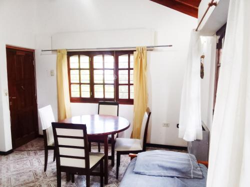 een eetkamer met een tafel en stoelen en een raam bij Norte, 310 in Villa Gesell