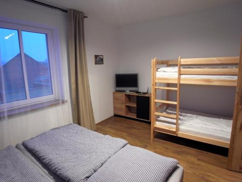 sypialnia z 2 łóżkami piętrowymi i telewizorem w obiekcie Apartmány Pekárna w mieście Staré Město