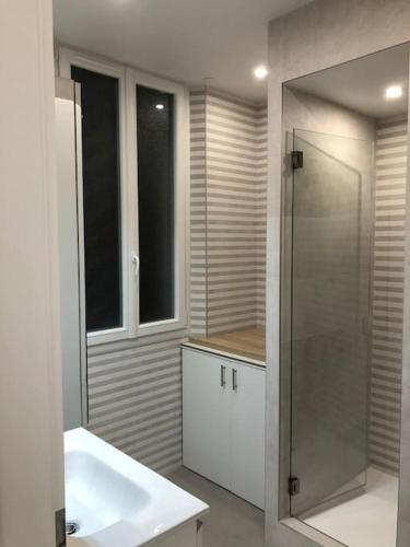 une salle de bain avec une douche en verre et un lavabo dans l'établissement 3 pièces Métro Marcel Sembat, à Boulogne-Billancourt