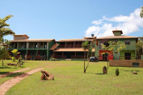 a building with a grass yard in front of it at Pousada Bela Vista do Ismail - Lapinha da Serra in Santana do Riacho