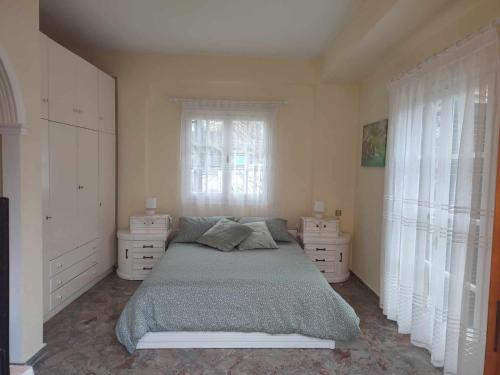 a bedroom with a bed and two dressers and a window at Potami Studios in Lefkímmi