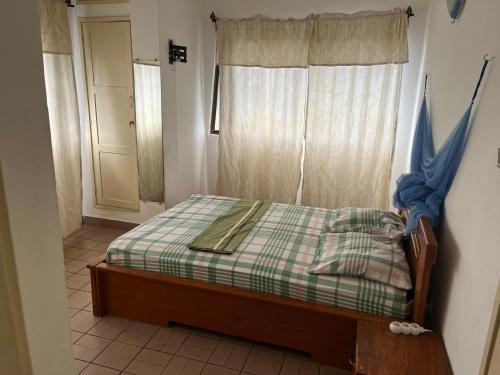 a small bed in a room with a window at Luxious Cosy Apart 2 Bedroom Cotonou Centre in Cotonou