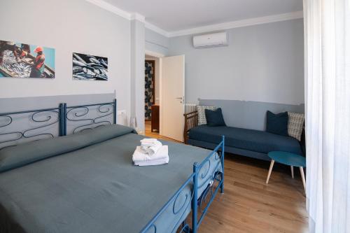 1 dormitorio con 1 cama azul y 1 sofá en U MAE MA, UN PASSO DAL MARE, en Bogliasco