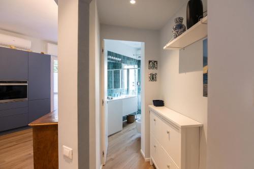 a kitchen with white cabinets and a large window at U MAE MA, UN PASSO DAL MARE in Bogliasco