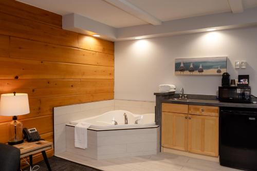 a bath tub in a kitchen with wooden walls at Terrace Suites in Callander