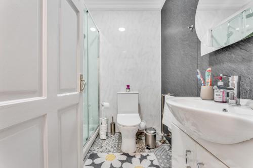 La salle de bains est pourvue de toilettes blanches et d'un lavabo. dans l'établissement Central London Oxford Street One Bedroom Apartment, à Londres