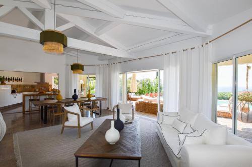een woonkamer met een witte bank en een tafel bij Villa Les Agrumes vue panoramique sur mer in La Croix-Valmer