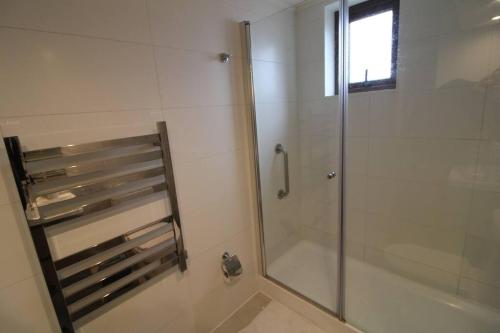 um chuveiro com uma porta de vidro na casa de banho em TuArriendoCL-MPHA106 Gran Depto en Pto Varas 3D2B 6PAX sin vista primer piso con jardin em Puerto Varas