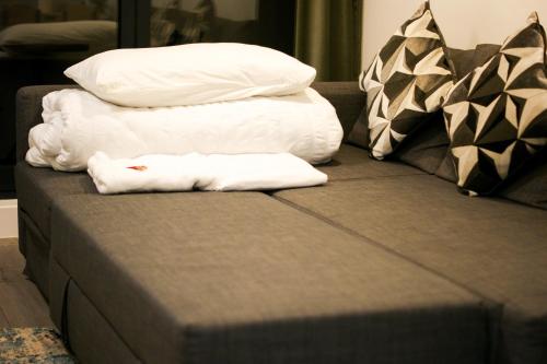 a couch with two pillows and two towels on it at The Madison Apartment by GGE, Hemel Hempstead Town Centre, Contractors Welcome, Sleeps 6 in Hemel Hempstead