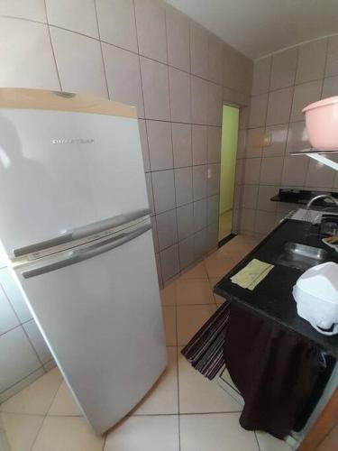 uma cozinha com um frigorífico branco e um lavatório em Excelente Localização em Jacaraípe em Serra
