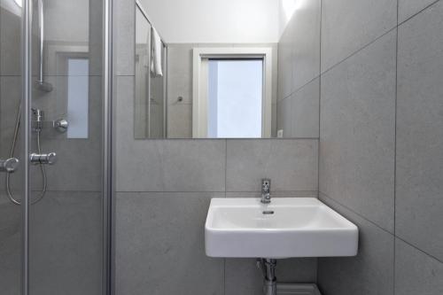 a bathroom with a sink and a shower and a mirror at Hotel AMITY in Prague
