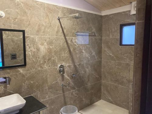 a bathroom with a shower and a sink at Sattal Valley Resort in Bhīm Tāl