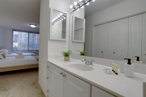 La salle de bains est pourvue d'un lavabo et d'un grand miroir. dans l'établissement Sensational Condominium @Crystal City, à Arlington