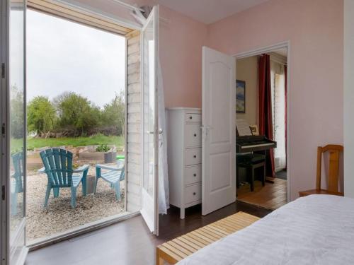 a bedroom with a door open to a patio with a piano at 5 bedroom-5 bathroom Gîte with free wifi and parking chez Mostarlić B&B in Bouconville