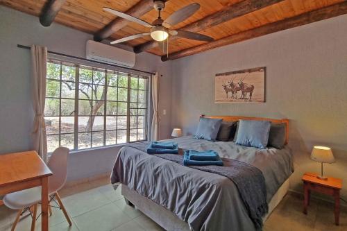 a bedroom with a bed and a ceiling fan at Greater Kruger View - Luxury Bush Villa in Marloth Park
