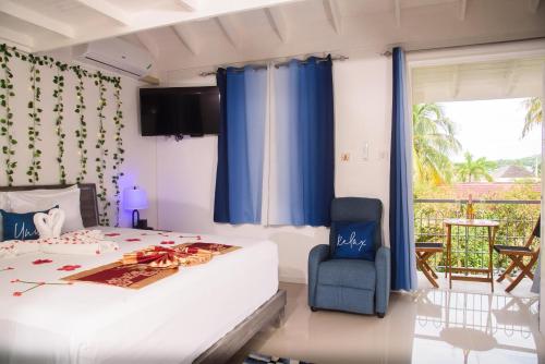 a bedroom with a bed and a blue chair at Czar's Oasis Apt B27 @ Ocho Rios in Ocho Rios