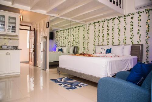 a bedroom with a white bed and a blue chair at Czar's Oasis Apt B27 @ Ocho Rios in Ocho Rios