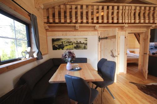 a dining room with a table and a couch at Almdorf im Winkl - Blockhüttendorf in Gröbming in Gröbming
