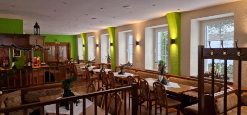 Olbersdorf的住宿－Olbersdorfer Hof，餐厅设有桌椅和绿色的墙壁