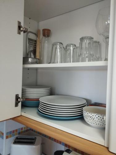 a cupboard filled with plates and other dishes at My Suites Madrid - Aeropuerto Ifema in Madrid