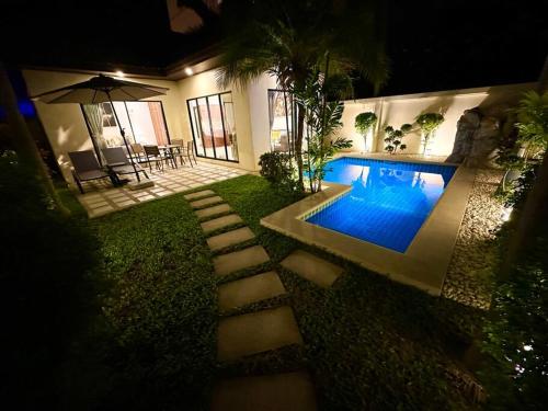 a backyard with a swimming pool at night at View Talay Villas - Luxury, 1 Bedroom - private pool villa, 500m from Jomtien beach - VTV 57 in Jomtien Beach