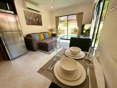 a dining room table with plates and wine glasses at View Talay Villas - Luxury, 1 Bedroom - private pool villa, 500m from Jomtien beach - VTV 57 in Jomtien Beach
