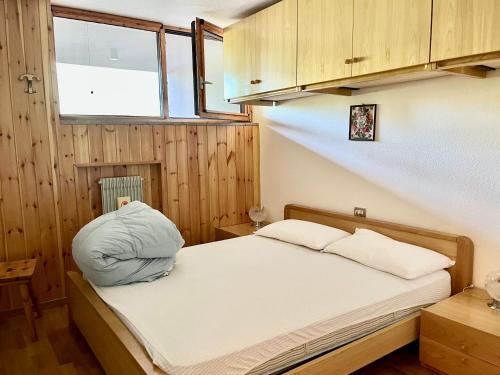 1 dormitorio con cama con almohada en Appartamento - Residence I Larici en Folgarida