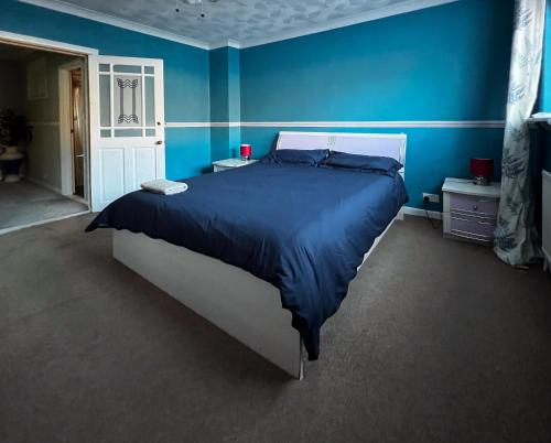 a bedroom with a large bed with blue walls at Spacious Retreat - Remote Worker & Family Friendly in Portsmouth