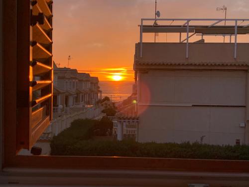 um pôr-do-sol visto de uma janela de um edifício em Apartment-House La Mata Torrevieja em Torrevieja