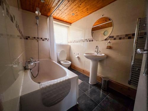 een badkamer met een bad, een wastafel en een toilet bij Spacious Retreat - Remote Worker & Family Friendly in Portsmouth