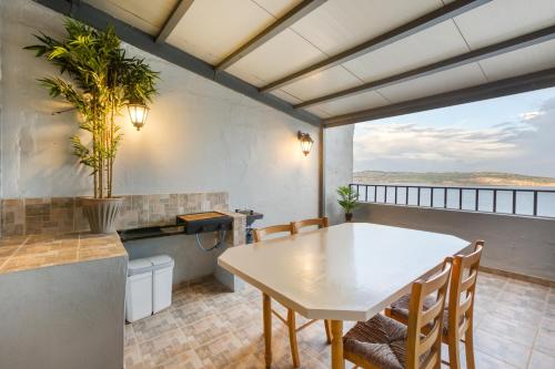 una sala da pranzo con tavolo e sedie di SPB26 - Seafront House in Bugibba a San Pawl il-Baħar