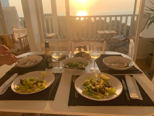 une table avec des assiettes de nourriture et des verres de vin dans l'établissement Vacances à Trouville en famille vue mer, à Trouville-sur-Mer