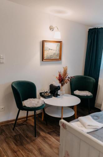 a room with two green chairs and a table at Penzion U Zběhlíka in Svitavy