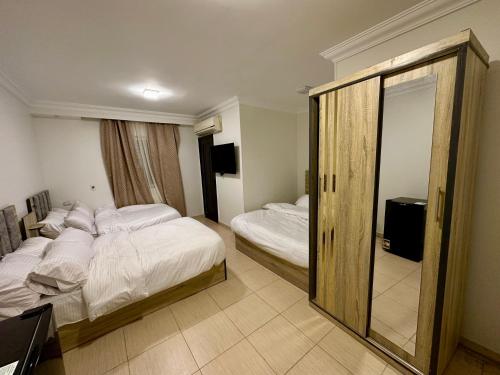 Habitación de hotel con 2 camas y espejo en Pyramids Serenity, en El Cairo