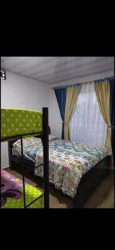 a bedroom with a bed and a window with curtains at Cabaña hospedaje las Gaviotas in Moñitos
