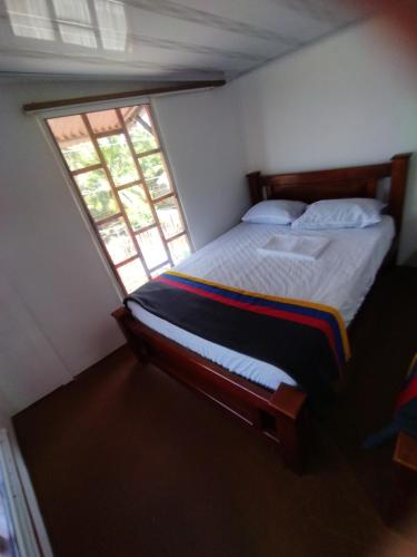 una camera da letto con un letto e una grande finestra di Cabaña hospedaje las Gaviotas a Moñitos