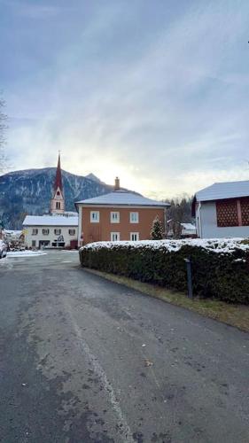 a street with a building and a church with snow at Apartment Sonnleitner in Kötschach