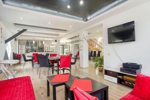 a living room with red furniture and a flat screen tv at Casa Preto E Branco in Moieciu de Jos