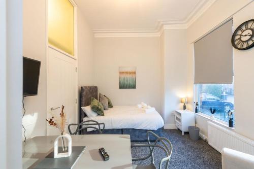 a hotel room with a bed and a clock on the wall at Benoît Apartments in Manchester