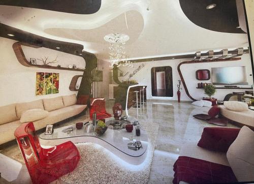 uma sala de estar com um sofá e cadeiras vermelhas em فيلا للإيجار في الشيخ زايد em ‘Ezbet `Abd el-Ḥamîd